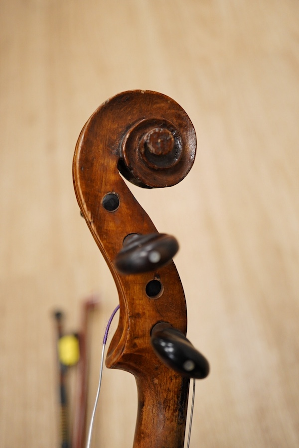 A late 19th century German violin, body 35cm long, and two bows. Condition - poor to fair.